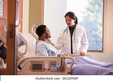 Female Doctor Talking To Male Patient In Hospital Bed