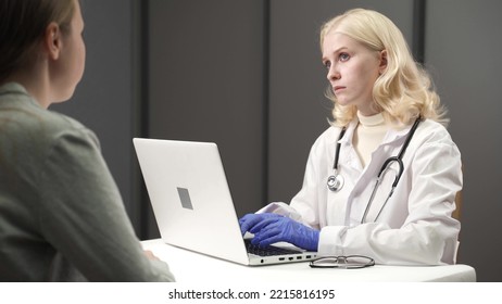 Female Doctor Talking With Patient During Visit At Doctors Office.