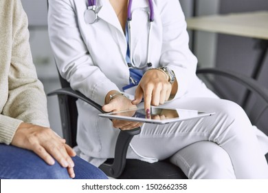 female doctor talking to a patient on a tablet