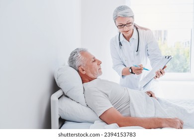 Female doctor telling male patient the results of his medical tests. Nurse caregiver taking notes, giving prescriptions to patient, prescribing drugs and pills - Powered by Shutterstock