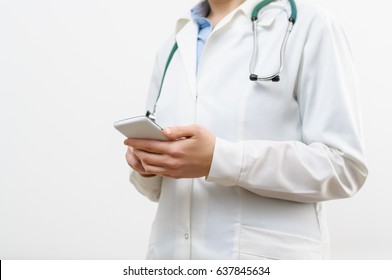 A Female Doctor Texting On Smartphone In Medical Office