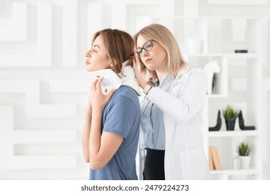 Female doctor traumatologist-orthopedist explaining to her patient with serious neck injury in neck brace about importance of cervical collar for healthy cure - Powered by Shutterstock