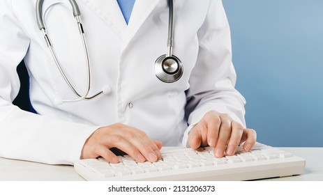 Female Doctor Typing On Computer Keyboard Mid-section