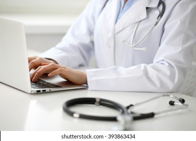 Female Doctor Typing On Laptop, Close Up