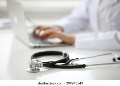 Female Doctor Typing On Laptop, Close Up