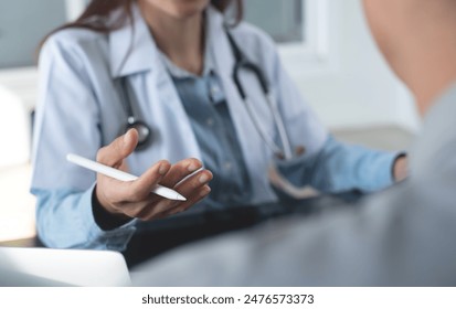 Female doctor using digital tablet computer, explaining to patient about checkup result, medical screening, giving consultation on appointment at medical clinic, close up - Powered by Shutterstock