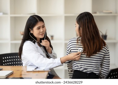 Female doctor using stethoscope to examine patient in doctor's office - Powered by Shutterstock