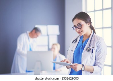 Female doctor using tablet computer in hospital lobby - Shutterstock ID 1332629003