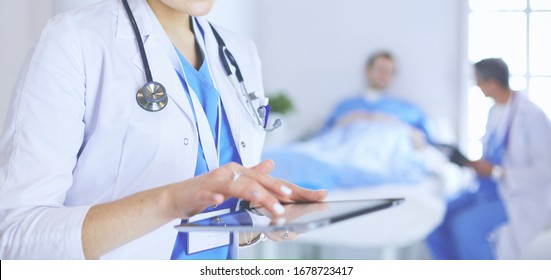 Ärztin, die einen Tablet-Computer in der Krankenhauslobby benutzt