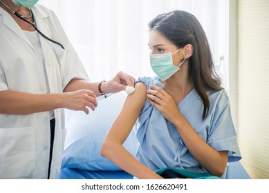 The Female Doctor Vaccinated Or Syringe To Injection To The Young Patient Put On A Mask In The Hospital.Medical Healthcare Concept.