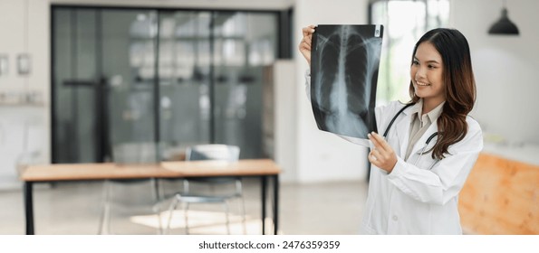 Female doctor in white coat holding and examining an X-ray in a modern medical office with bright natural light. - Powered by Shutterstock