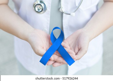 Female Doctor In White Uniform With Blue Ribbon Awareness In Hands For Addiction Recovery Awareness,Alopecia ,Acute Respiratory Distress Syndrome (ARDS), Apraxia, Arthritis Awareness An Beat Bullying.