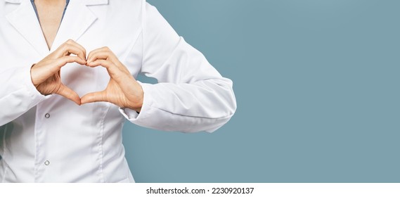 Female doctor in white uniform forms a heart shape with her hands. Minimal on blue background. Banner copy space. Heart, cardiology and medical care support and assistance female health gynecology - Powered by Shutterstock