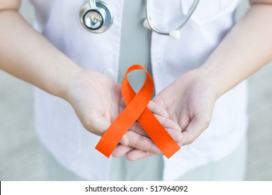 Female doctor in white uniform with orange ribbon awareness in hand as stop sign for ADHD,COPD,Cultural Diversity,Kidney Cancer - Renal Cell Carcinoma,Leukemia, Lupus,Malnutrition,Self Injury,Spinal - Powered by Shutterstock