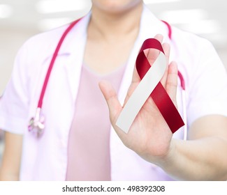 Female Doctor In White Uniform With Red And White Ribbon Awareness In Hand As Stop Sign For Aplastic Anemia,Deep Vein Thrombosis (DVT),Head & Neck Cancer,Oral Cancer,Squamous Cell Carcinoma.