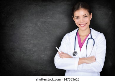 Female doctor woman teaching at medical school. Young female medical professional teacher, professor or medical student giving lecture by blackboard standing with chalk. Asian Caucasian model.