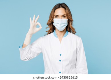 Female doctor woman wearing white medical gown suit mask gloves work in hospital clinic office show ok okay gesture look camera isolated on plain blue background studio. Health care medicine concept - Powered by Shutterstock