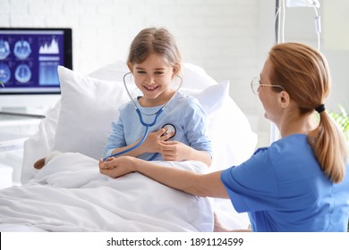 Female doctor working with little girl in hospital room - Powered by Shutterstock