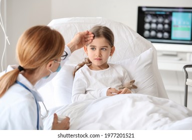 Female Doctor Working With Little Girl In Hospital Room