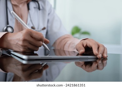 Female doctor working, using digital tablet at doctor's office. writing prescripstion, recording patient's information, healthcare and medicine concept, close up - Powered by Shutterstock