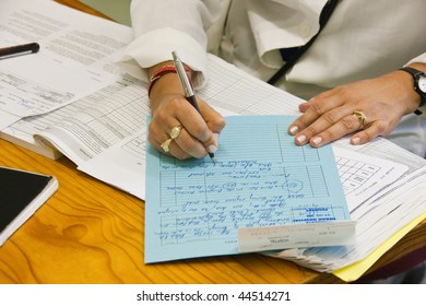 Female Doctor Writing A File For A Patient In The Hospital