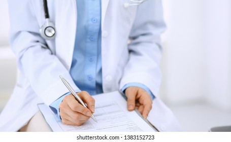 Female Doctor Writing Up Medication History Records Form On Clipboard, While Sitting At The Chair. Physician At Work In Hospital Or Clinic. Healthcare, Insurance And Medicine Concept