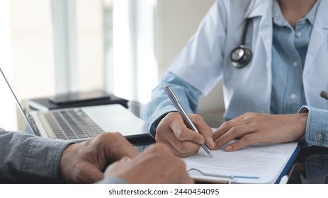 Female doctor writing a prescription for her patient. Docotr filling medical insurance claim form at medical clinic, healthcare and medicine concept, close up - Powered by Shutterstock