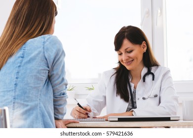 Female Doctor Writing Prescription To Patient