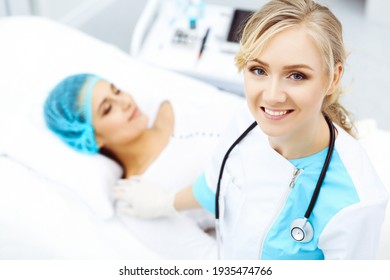 Female Doctor And Young Woman Patient In Hospital. Physicians Examine Girl Lying At The Bed, View From Above