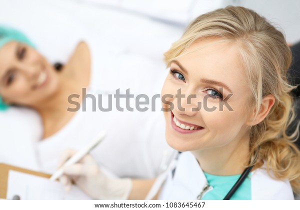 Female doctor and young woman patient in hospital. Physicians examine