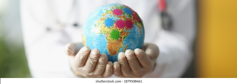 Female Doctor's Hands In Gloves Hold Globe. Disease Spread Around The World Concept