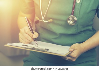  female doctor,surgeon,nurse,pharmacy with stethoscope on hospital holding clipboard,writing a prescription,Medical Exam,Healthcare and medical concept,test results,vintage color,selective focus