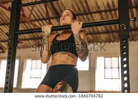 Similar – Image, Stock Photo Woman Exercising on Pull-up Bar in Gym