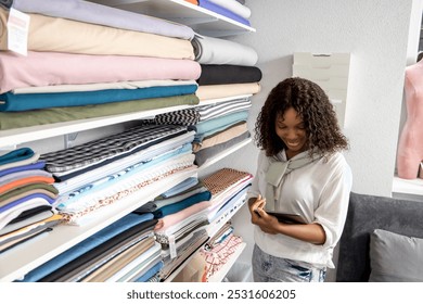 Female dressmaker in retail store choosing fabric using tablet to check stock place orders online - Powered by Shutterstock