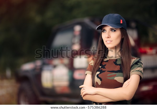 Female Driver in Army Outfit Next to an Off\
Road Car - Portrait of a woman in a camouflage print t-shirt\
standing beside an\
automobile\
