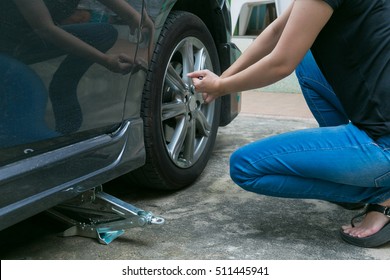 Female Driver Changing Tyre On Her Broken Car.