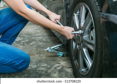 Female Driver Changing Tyre On Her Broken Car.