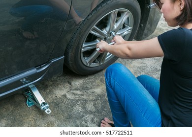 Female Driver Changing Tyre On Her Broken Car.