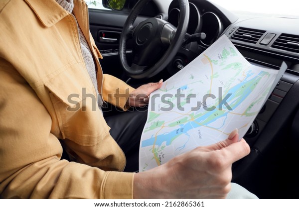 Female driver with\
city map in car, closeup