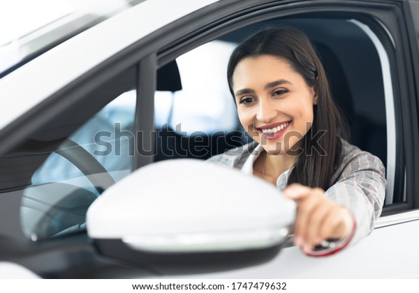 Female Driver Concept. Smiling Girl\
Correcting Side Mirrors Sitting In Driver\'s\
Seat