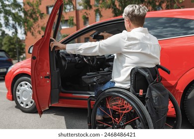 Female driver with disability entering a car, a wheelchair user on the way to work. Concepts of accessibility, transport, and safety. - Powered by Shutterstock