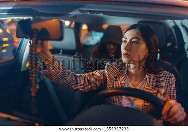 Female driver\
and hooded car robber on back\
seat