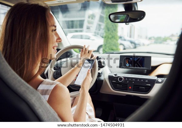 Female driver inside of modern automobile. Testing\
brand new car.