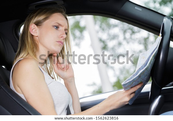 female driver looking at\
map
