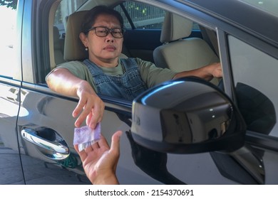 Female Driver Opens Her Car Window To Give Money To Someone Outside