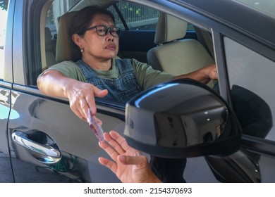 Female Driver Opens Her Car Window To Give Money To Someone Outside