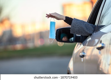 Female Driver Throws Out A Used Facial Mask Through A Car Window Or Shares A New Clear With Somebody, Copy Space