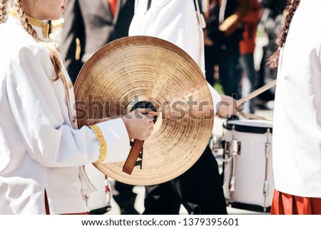 Female Drummer Ensemble in a white full dress, performing in the spring in the city park.