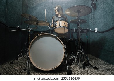 Female drummer performing on professional drum set in soundproof studio, focusing on rhythm and energy of live music creation. Scene highlights passion for music, performance, and artistic expression - Powered by Shutterstock