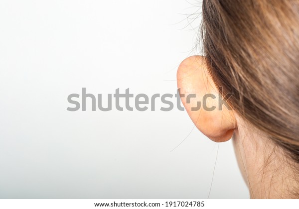 Female ear, lop-eared, protruding, close-up on a\
light background. Auricle\
defect